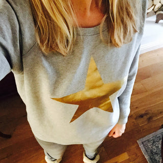 Metallic gold star on a light grey sweatshirt