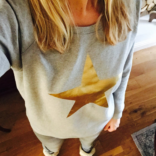 Metallic gold star on a light grey sweatshirt