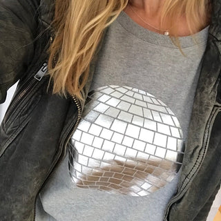 Silver disco ball on a light great sweat