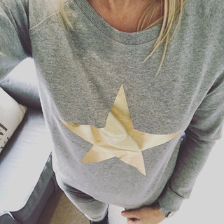 Metallic gold star on a light grey sweatshirt