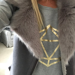 Metallic gold octahedron on a light grey sweat