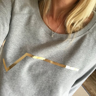 Gold diagonal stripe on light grey sweatshirt
