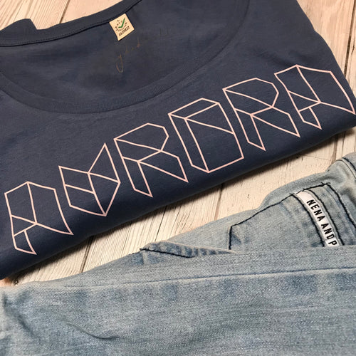 Pink geometric aurora font on denim blue tee